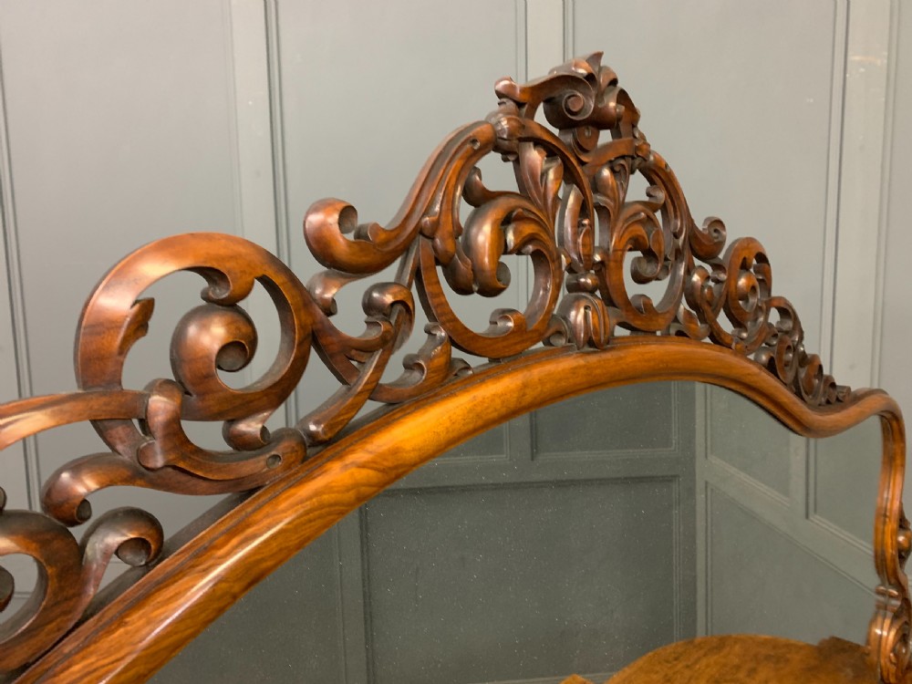 A Victorian burr walnut chiffonier featuring open side display shelves, mirrored central cabinet doors, and an ornate carved mirror frame cresting. View XXII