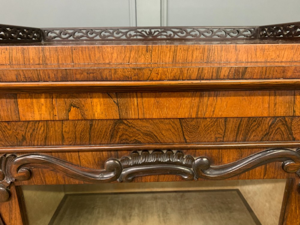 A tall Victorian rosewood bookcase cabinet featuring a single glazed door with carved scrollwork borders and a fretwork top gallery. View V