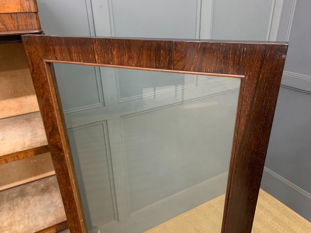 A tall Victorian rosewood bookcase cabinet featuring a single glazed door with carved scrollwork borders and a fretwork top gallery. View XII
