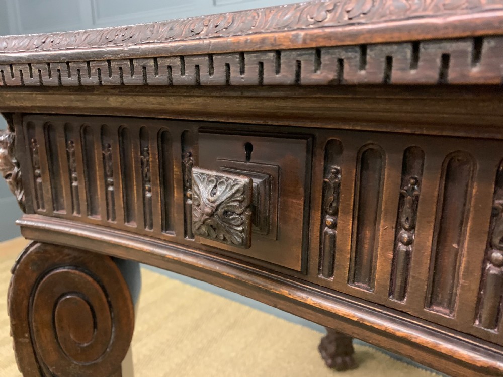 A carved mahogany writing table with a three-section inset leather top, detailed frieze carvings, and carved legs with claw feet. View VIII