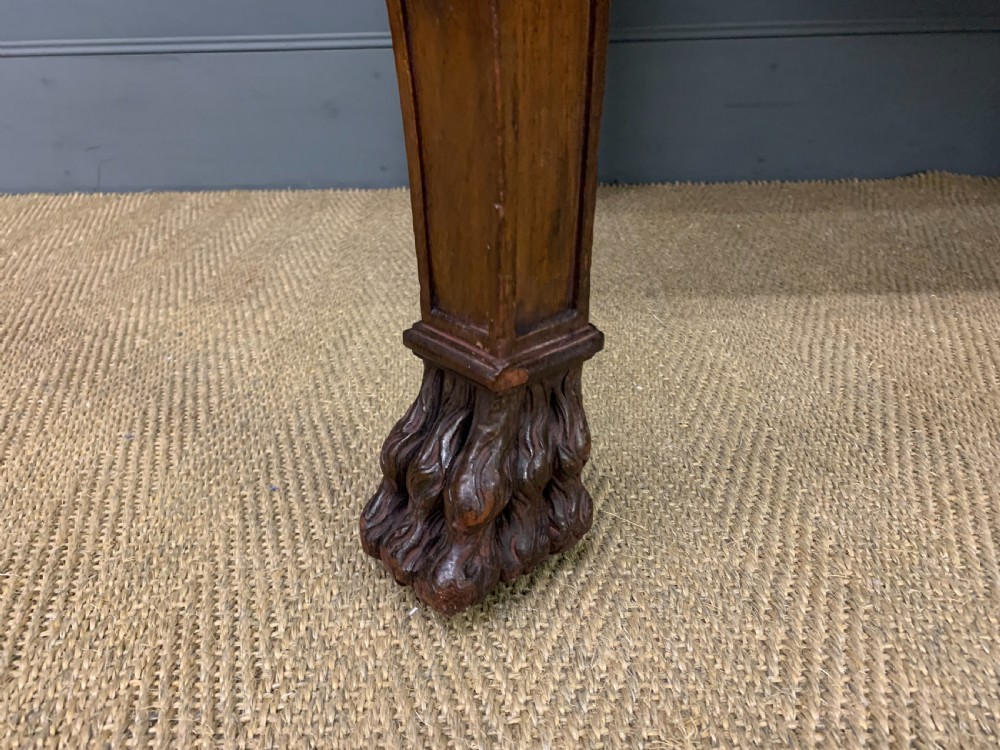 A carved mahogany writing table with a three-section inset leather top, detailed frieze carvings, and carved legs with claw feet. View IX