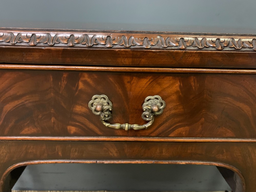 A flame mahogany Chippendale style writing desk featuring a shaped top, five brass-handled drawers, and carved cabriole legs with ball and claw feet. View VI