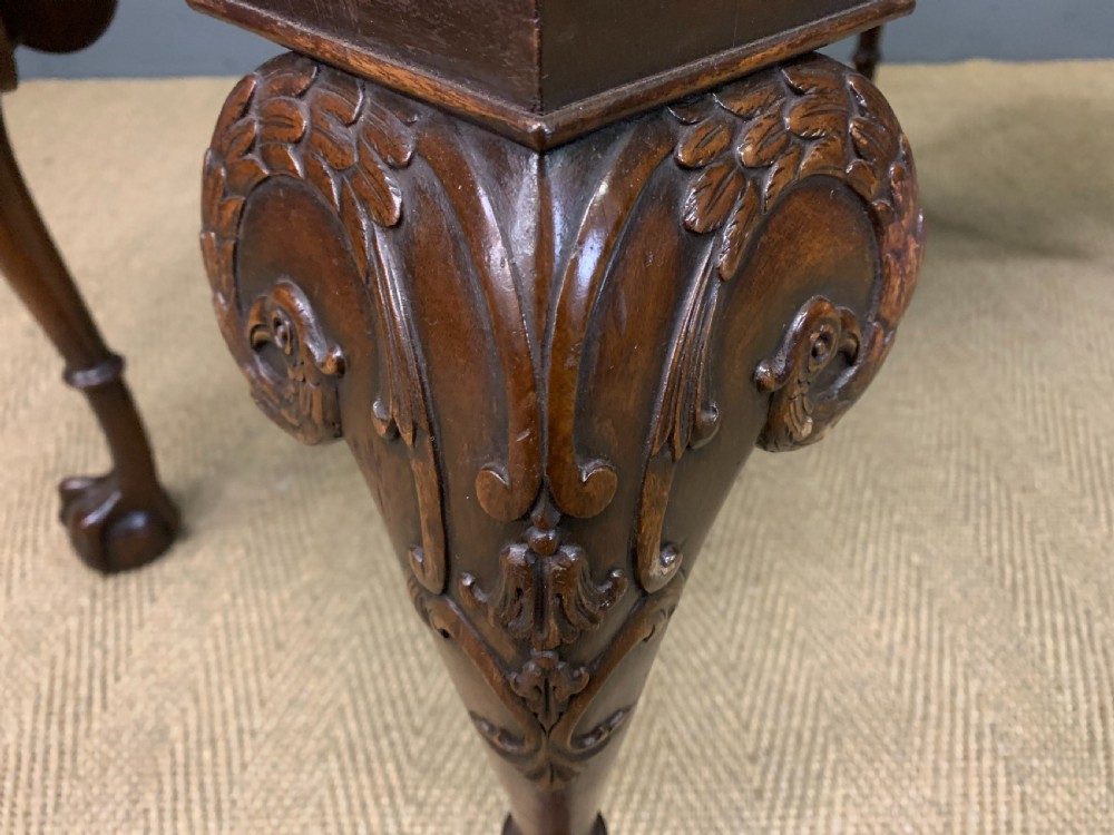A flame mahogany Chippendale style writing desk featuring a shaped top, five brass-handled drawers, and carved cabriole legs with ball and claw feet. View XV