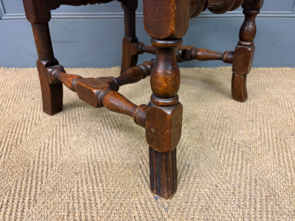 A set of three dark timber Carolean style side chairs featuring high arched carved cresting, woven cane backrest panels, cane seats, and turned stretchers. View XI
