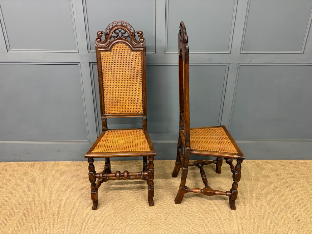 A set of three dark timber Carolean style side chairs featuring high arched carved cresting, woven cane backrest panels, cane seats, and turned stretchers. View XIII