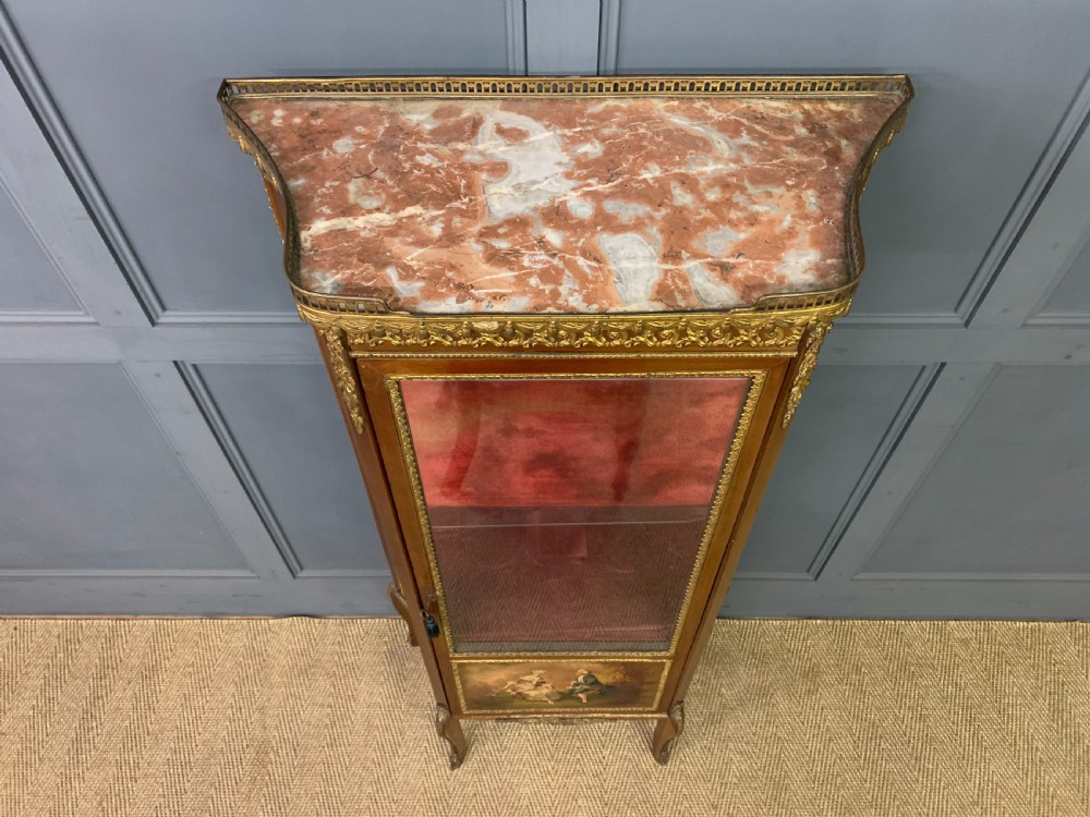 A French Louis XV style mahogany vitrine featuring a curved glazed door, gilt-bronze mounts, hand-painted lower panel depicting romantic figures, and a red velvet interior. View II