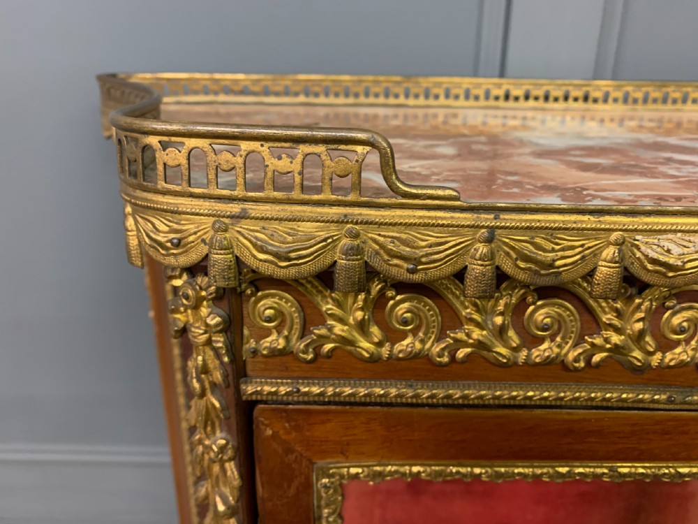 A French Louis XV style mahogany vitrine featuring a curved glazed door, gilt-bronze mounts, hand-painted lower panel depicting romantic figures, and a red velvet interior. View V