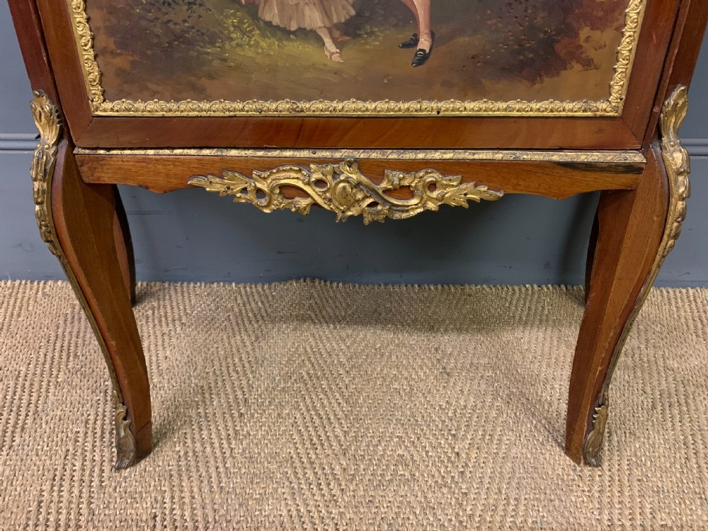 A French Louis XV style mahogany vitrine featuring a curved glazed door, gilt-bronze mounts, hand-painted lower panel depicting romantic figures, and a red velvet interior. View VII