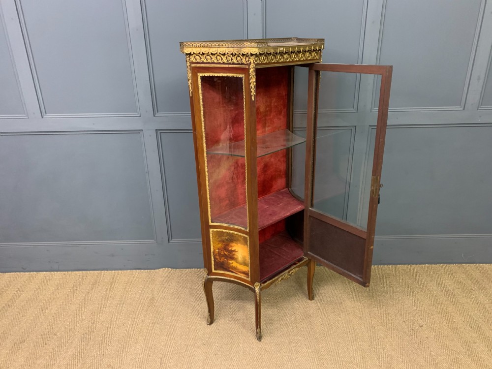 A French Louis XV style mahogany vitrine featuring a curved glazed door, gilt-bronze mounts, hand-painted lower panel depicting romantic figures, and a red velvet interior. View XIII