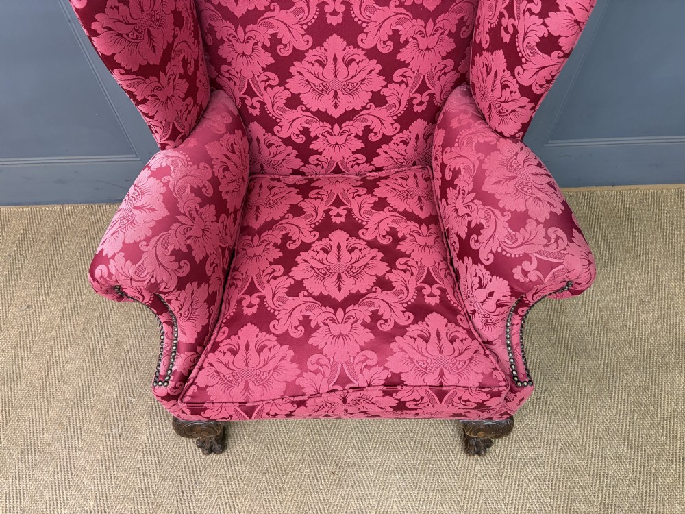 Late nineteenth-century wingback armchair upholstered in red damask fabric, featuring carved walnut cabriole legs with claw and ball feet. View II