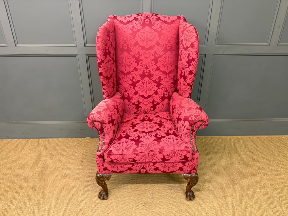 Late nineteenth-century wingback armchair upholstered in red damask fabric, featuring carved walnut cabriole legs with claw and ball feet. View III