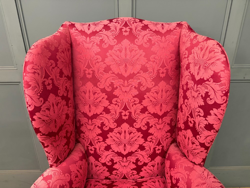 Late nineteenth-century wingback armchair upholstered in red damask fabric, featuring carved walnut cabriole legs with claw and ball feet. View IV