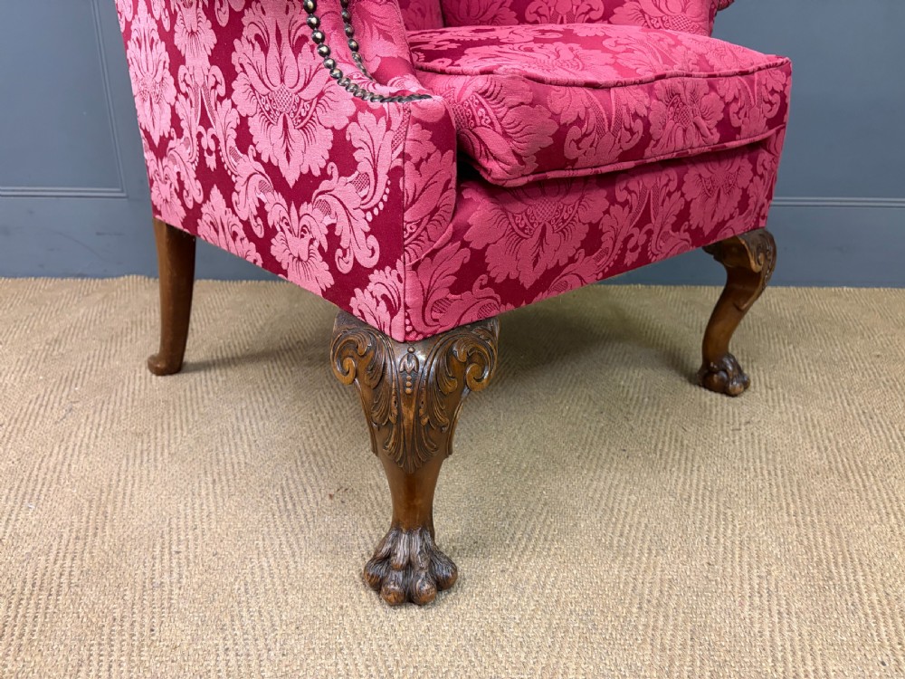 Late nineteenth-century wingback armchair upholstered in red damask fabric, featuring carved walnut cabriole legs with claw and ball feet. View VII