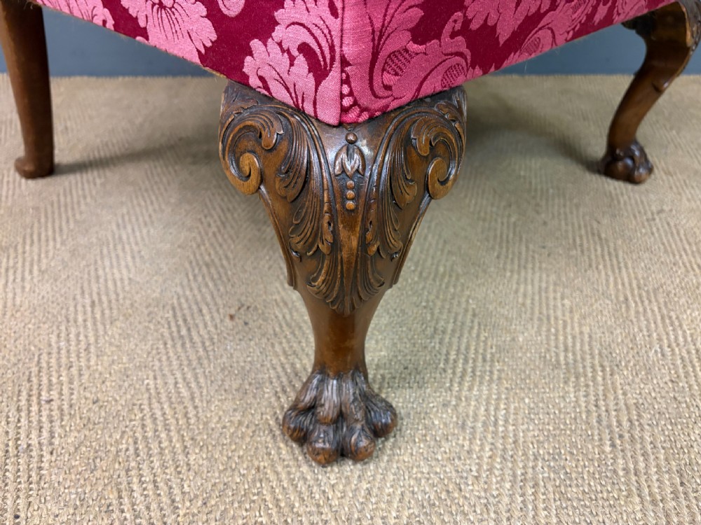 Late nineteenth-century wingback armchair upholstered in red damask fabric, featuring carved walnut cabriole legs with claw and ball feet. View VIII
