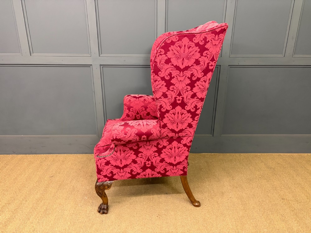 Late nineteenth-century wingback armchair upholstered in red damask fabric, featuring carved walnut cabriole legs with claw and ball feet. View XI