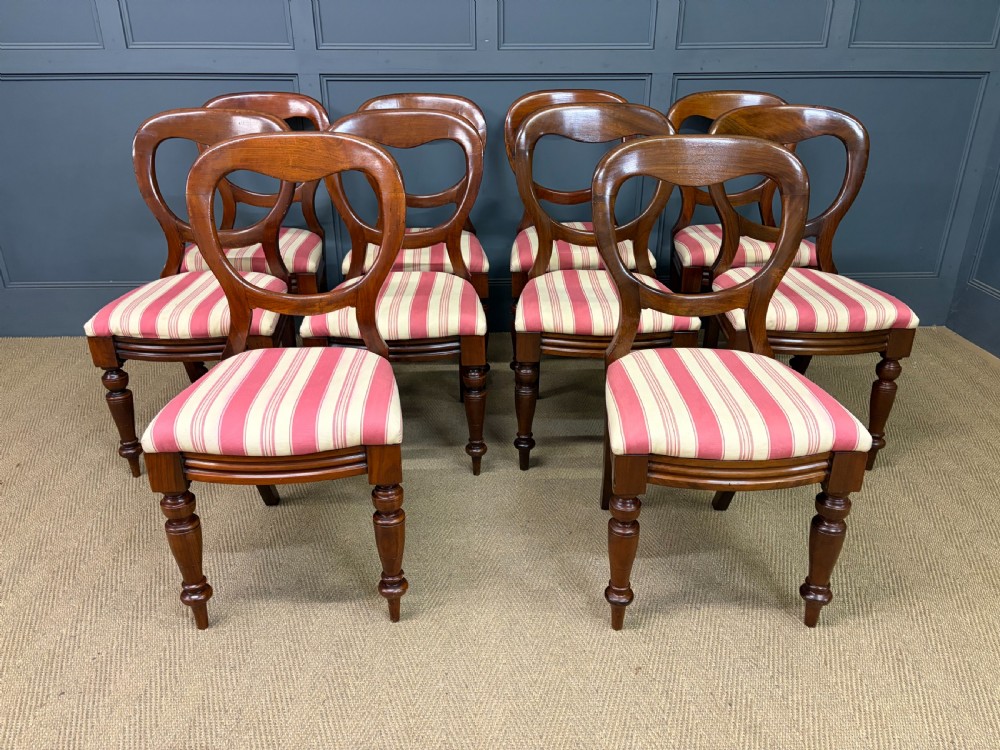 A set of ten Victorian mahogany balloon back dining chairs featuring turned front legs and red and cream striped upholstered seats. View II