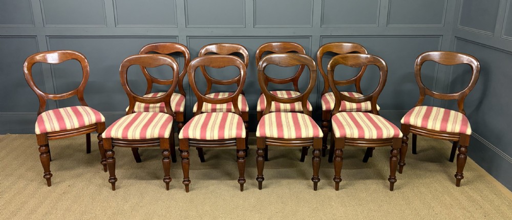 A set of ten Victorian mahogany balloon back dining chairs featuring turned front legs and red and cream striped upholstered seats. View III