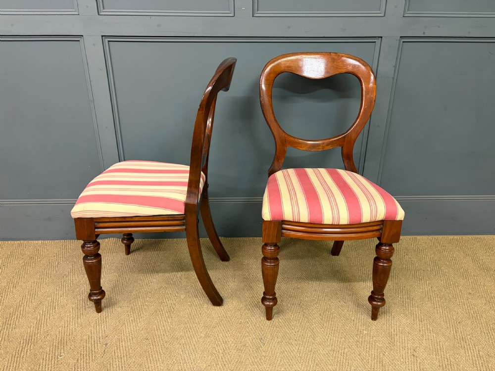 A set of ten Victorian mahogany balloon back dining chairs featuring turned front legs and red and cream striped upholstered seats. View IV