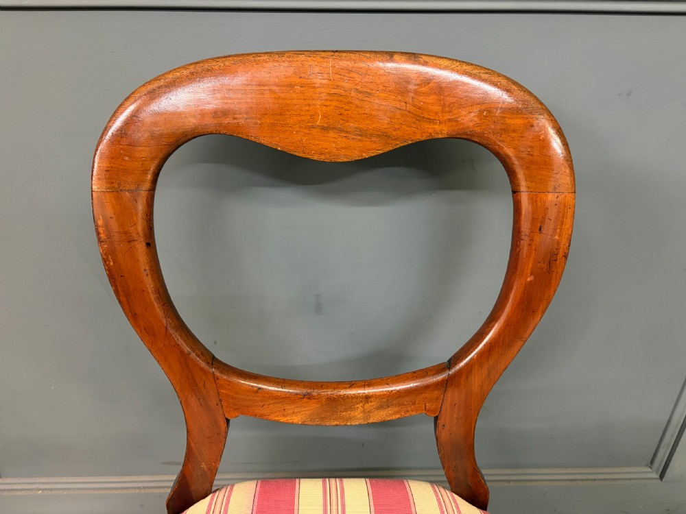 A set of ten Victorian mahogany balloon back dining chairs featuring turned front legs and red and cream striped upholstered seats. View VII