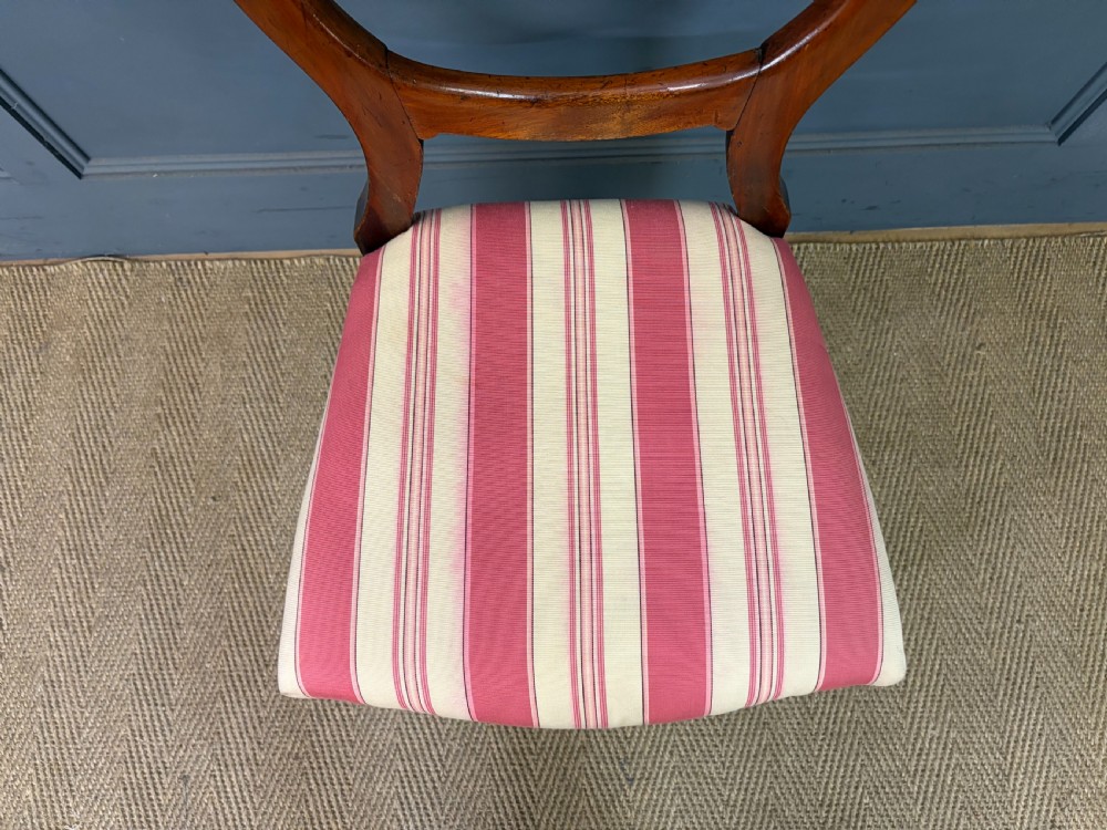 A set of ten Victorian mahogany balloon back dining chairs featuring turned front legs and red and cream striped upholstered seats. View VIII