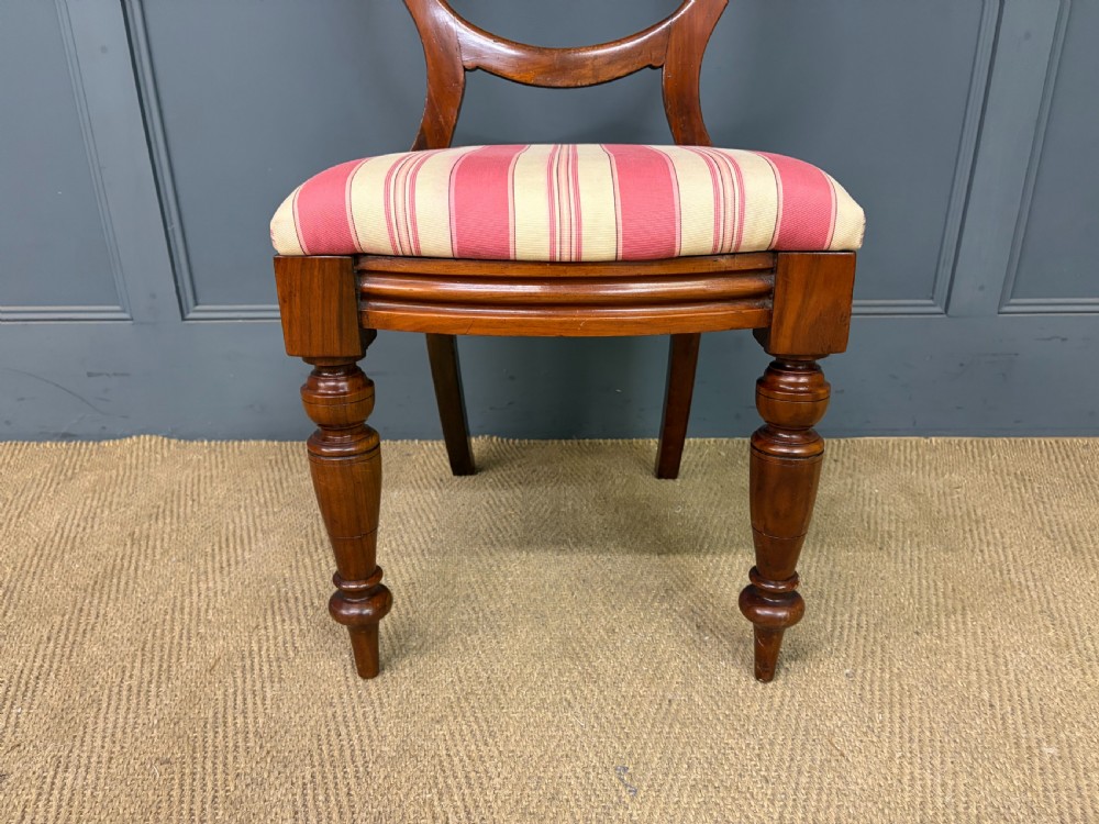 A set of ten Victorian mahogany balloon back dining chairs featuring turned front legs and red and cream striped upholstered seats. View IX