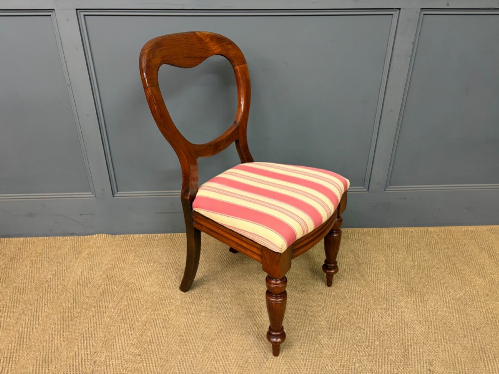 A set of ten Victorian mahogany balloon back dining chairs featuring turned front legs and red and cream striped upholstered seats. View X