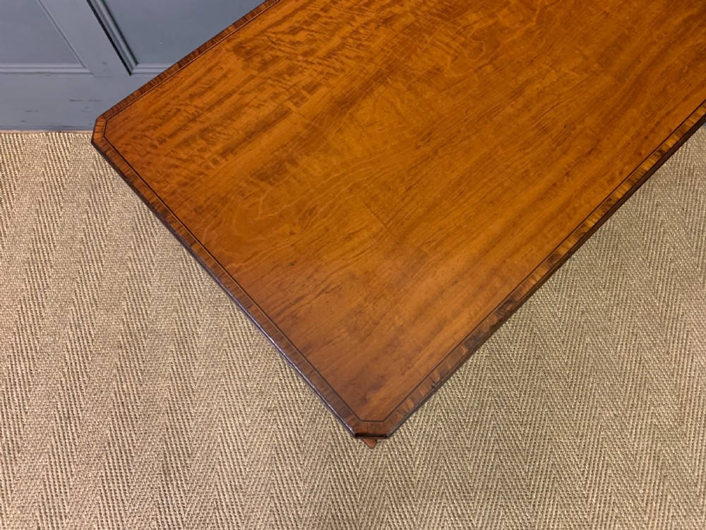 A nest of four graduated wooden tables featuring figure-grained satinwood tops with inlaid borders and slender turned legs. View VII