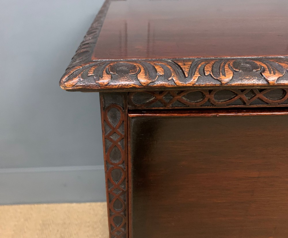 A wide dark mahogany Chippendale style chest featuring four drawers with oval brass handles, carved frieze detailing, and carved ball-and-claw feet. View VII