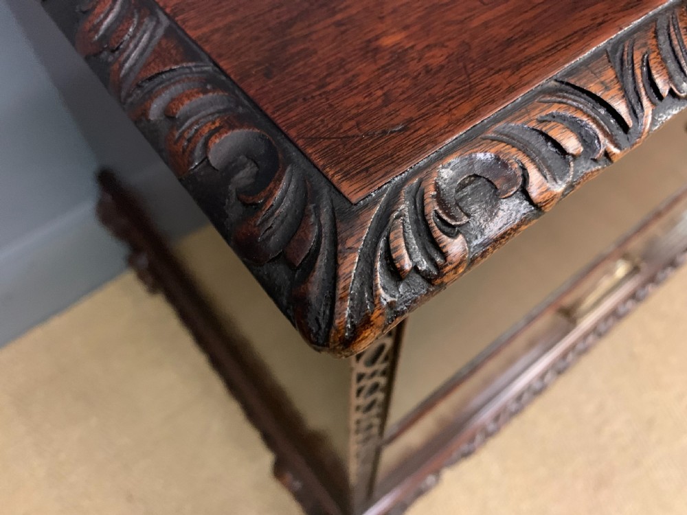 A wide dark mahogany Chippendale style chest featuring four drawers with oval brass handles, carved frieze detailing, and carved ball-and-claw feet. View X