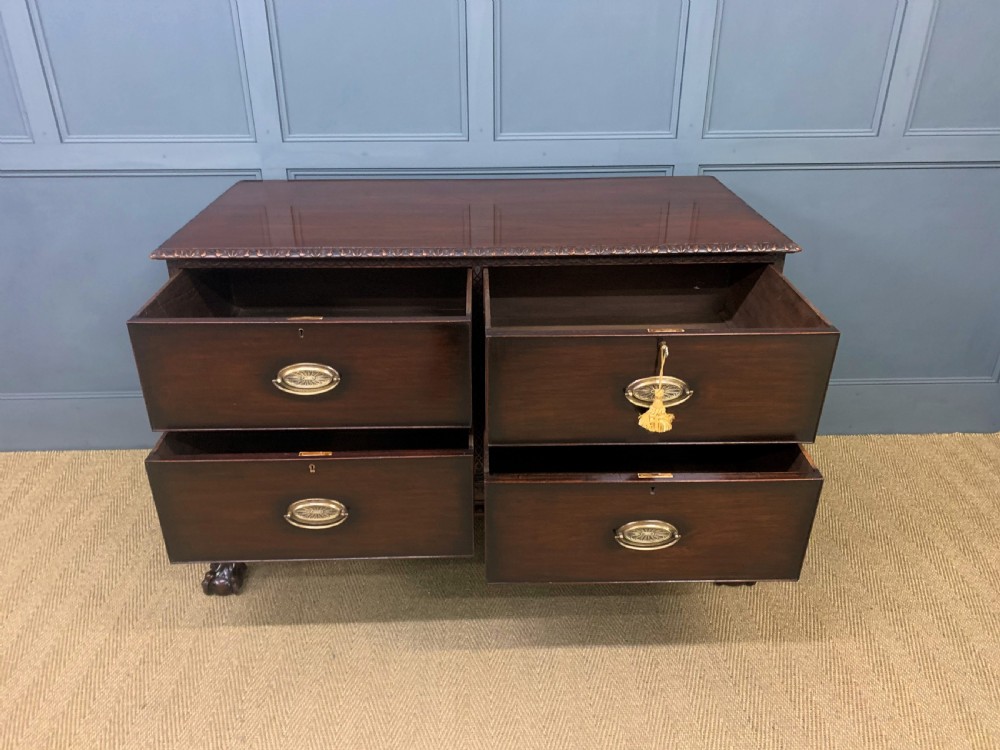 A wide dark mahogany Chippendale style chest featuring four drawers with oval brass handles, carved frieze detailing, and carved ball-and-claw feet. View XI