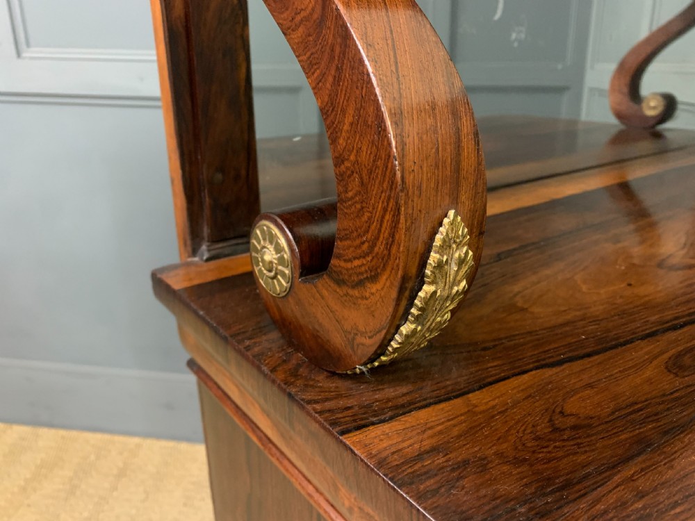 A Regency rosewood chiffonier cabinet featuring a top shelf with a brass gallery on S-scroll supports over a two-door cupboard with pleated yellow fabric panels. View XII