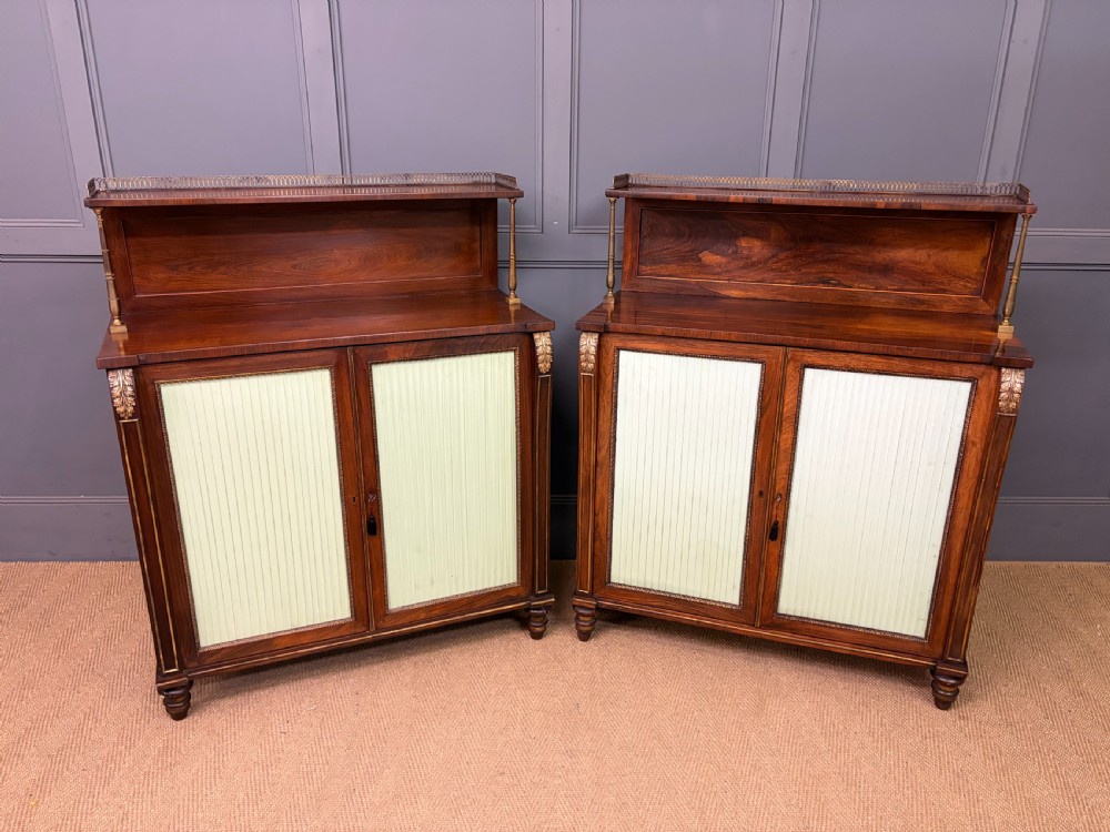 A pair of Regency period rosewood side cabinets featuring brass galleries, raised upper shelves, and pleated light green fabric door panels. View XI