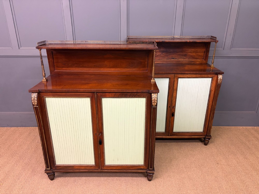 A pair of Regency period rosewood side cabinets featuring brass galleries, raised upper shelves, and pleated light green fabric door panels. View XIII