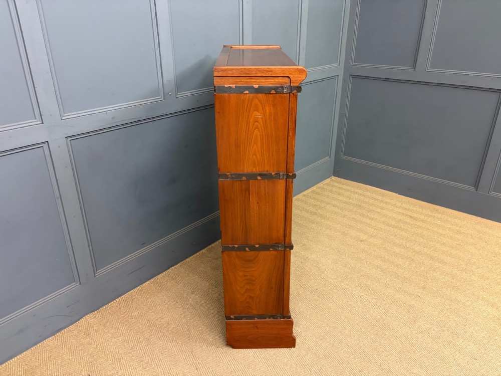 A three-tier walnut Globe Wernicke stacking bookcase featuring leaded glazed doors and a plinth base. View XIII