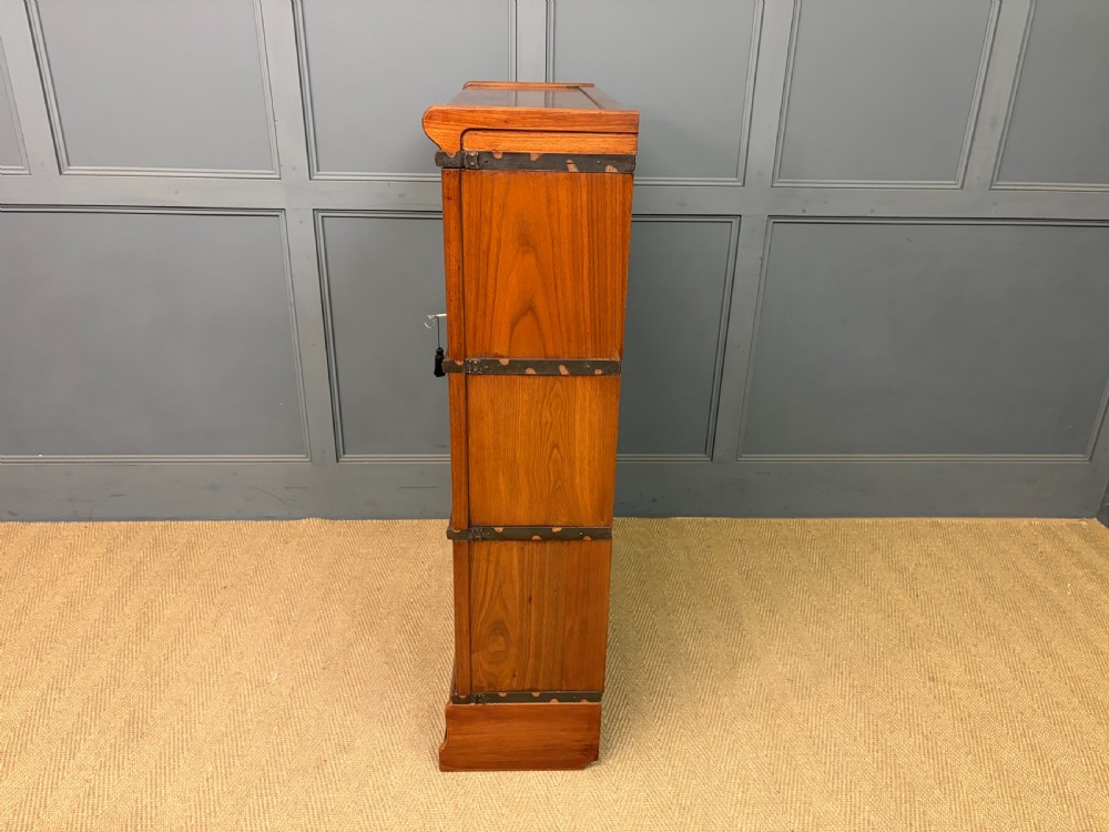 A three-tier walnut Globe Wernicke stacking bookcase featuring leaded glazed doors and a plinth base. View XV