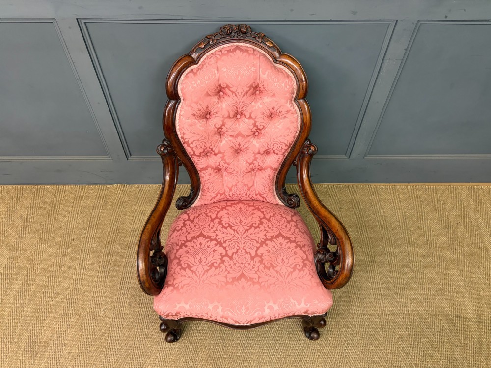 A pair of mid-Victorian carved walnut nursing chairs upholstered in buttoned pink damask fabric with cabriole legs. View IV