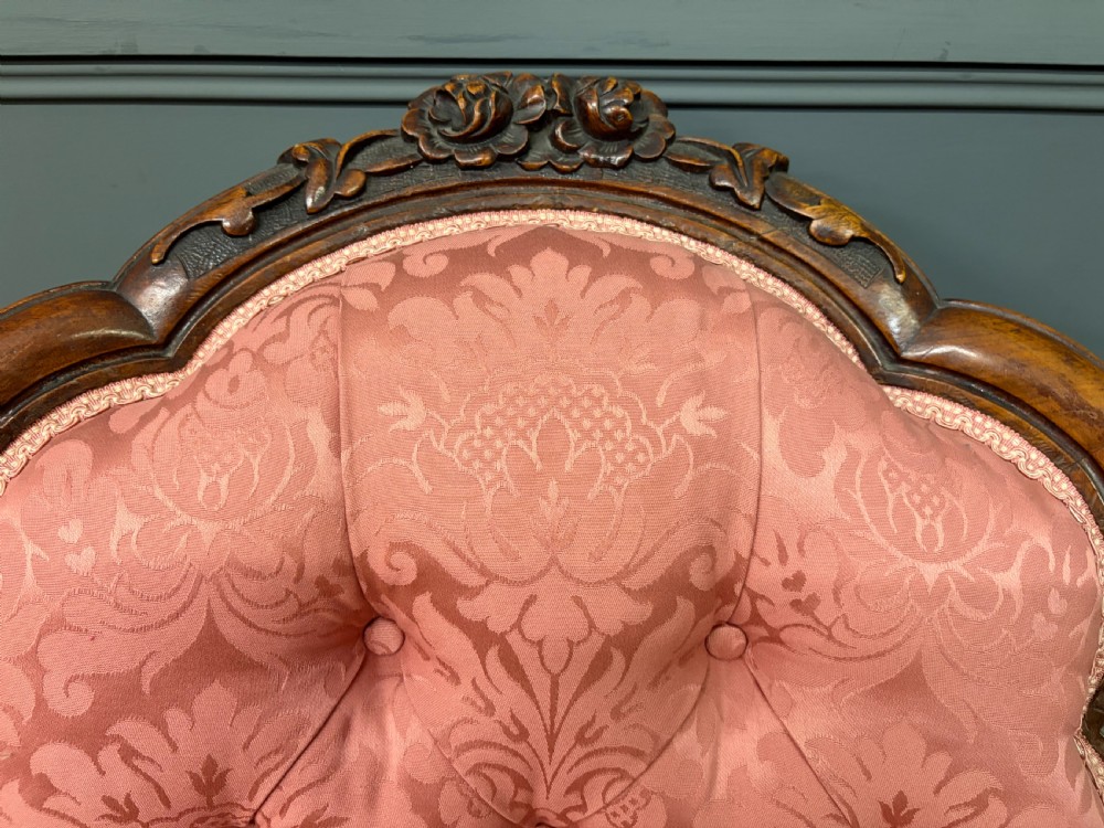 A pair of mid-Victorian carved walnut nursing chairs upholstered in buttoned pink damask fabric with cabriole legs. View VII