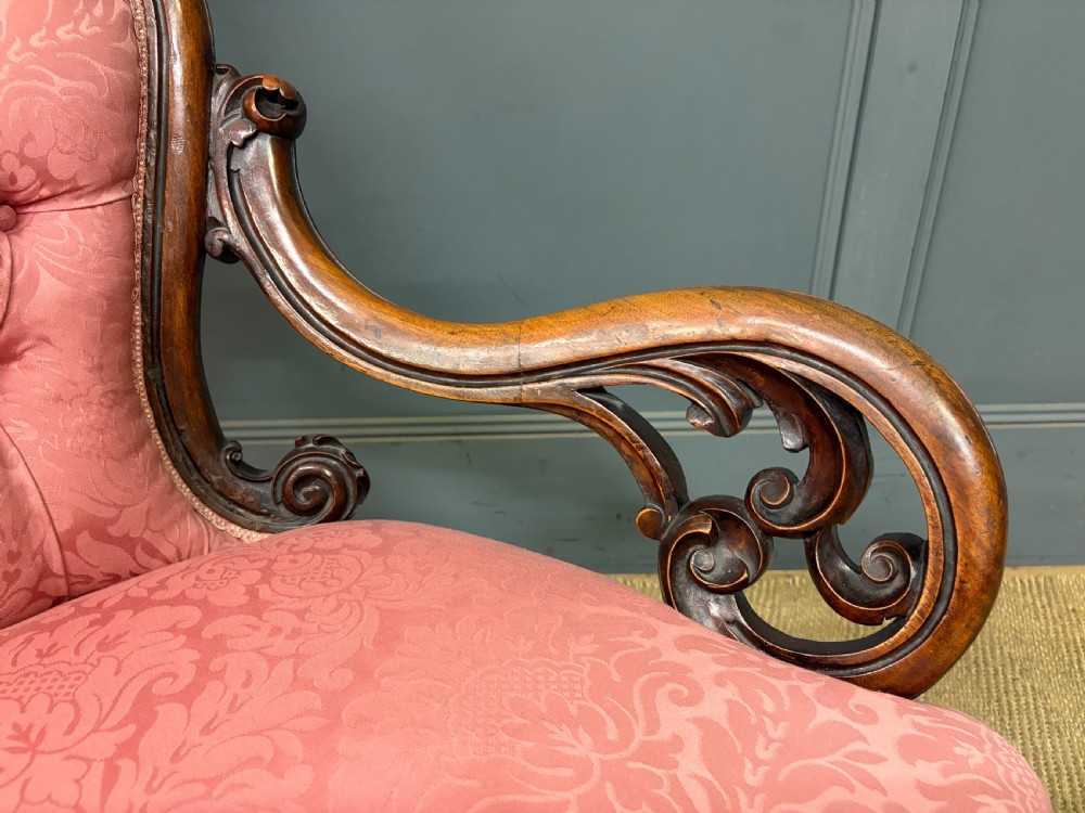 A pair of mid-Victorian carved walnut nursing chairs upholstered in buttoned pink damask fabric with cabriole legs. View VIII