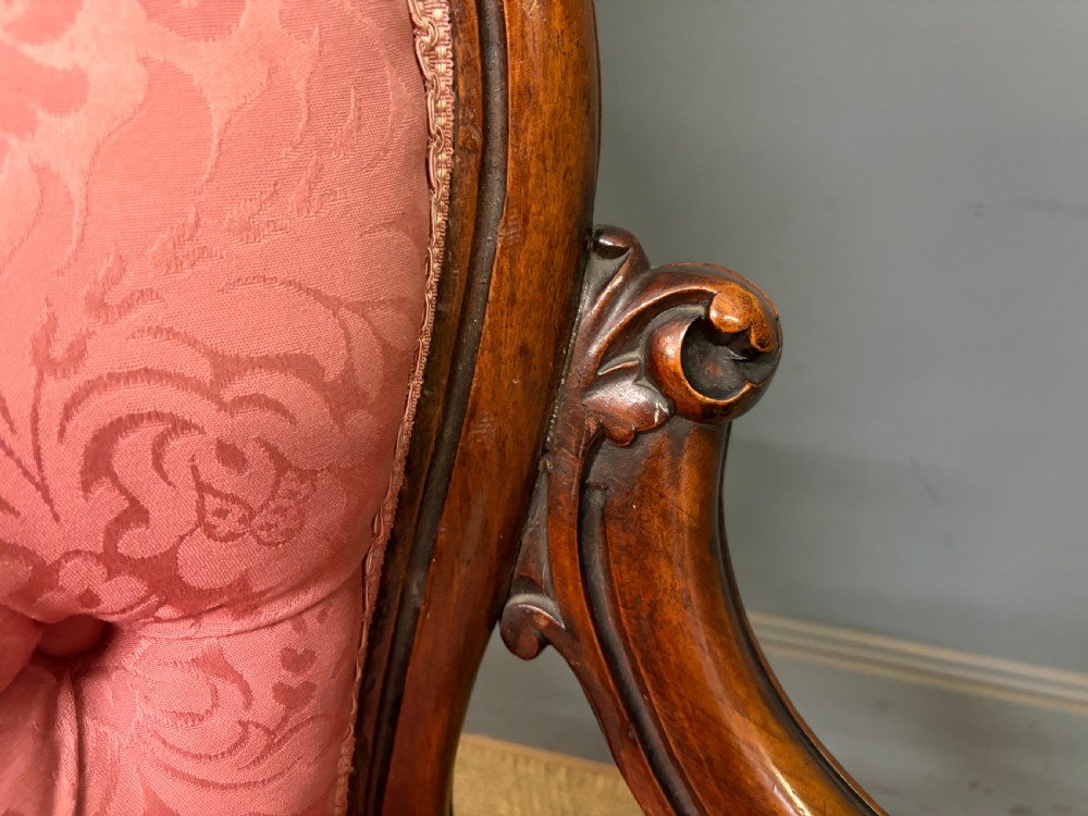 A pair of mid-Victorian carved walnut nursing chairs upholstered in buttoned pink damask fabric with cabriole legs. View IX