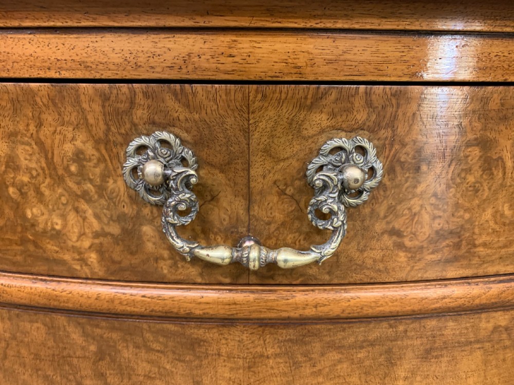 A pair of tall burr walnut pedestal cupboards featuring curved front doors, single top drawers with brass drop handles, and carved scroll feet. View XII