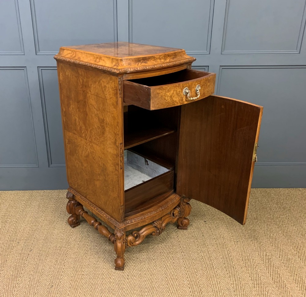 A pair of tall burr walnut pedestal cupboards featuring curved front doors, single top drawers with brass drop handles, and carved scroll feet. View XVIII