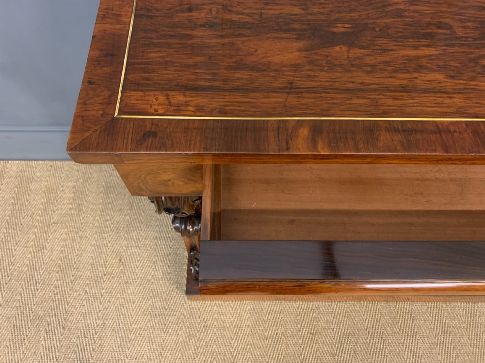 A dark Regency period rosewood side cabinet featuring two cupboard doors with gilded bronze trim and carved scroll supports on a plinth base. View VIII
