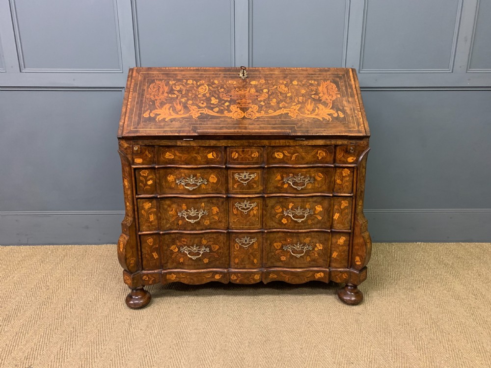 An 18th-century Dutch walnut bureau featuring detailed floral marquetry inlay across the slant-front lid and drawer fronts, accented with brass handles. View II