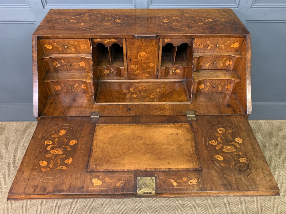 An 18th-century Dutch walnut bureau featuring detailed floral marquetry inlay across the slant-front lid and drawer fronts, accented with brass handles. View VIII