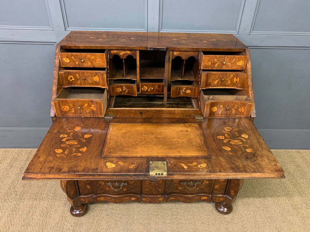 An 18th-century Dutch walnut bureau featuring detailed floral marquetry inlay across the slant-front lid and drawer fronts, accented with brass handles. View XII