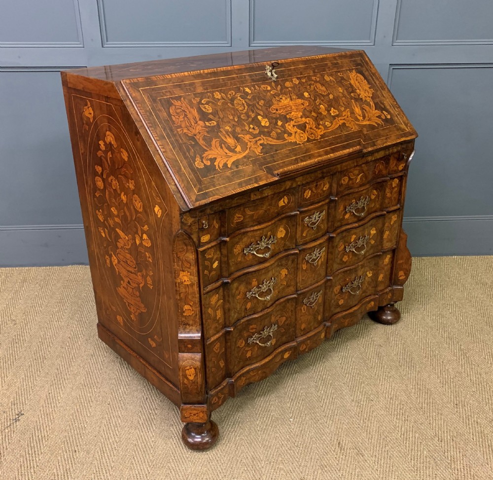 An 18th-century Dutch walnut bureau featuring detailed floral marquetry inlay across the slant-front lid and drawer fronts, accented with brass handles. View XIV