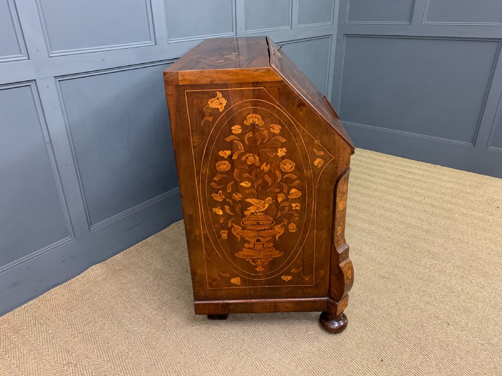 An 18th-century Dutch walnut bureau featuring detailed floral marquetry inlay across the slant-front lid and drawer fronts, accented with brass handles. View XV