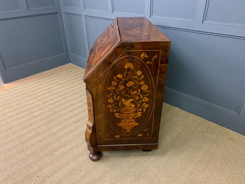 An 18th-century Dutch walnut bureau featuring detailed floral marquetry inlay across the slant-front lid and drawer fronts, accented with brass handles. View XIX