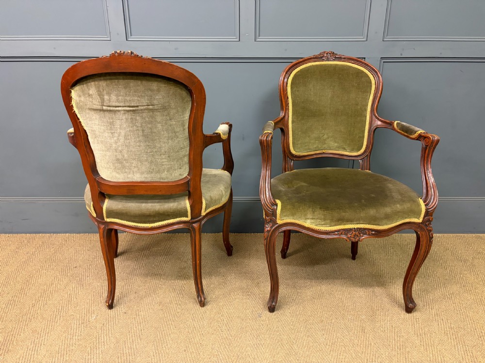 A pair of French carved mahogany fauteuil armchairs featuring cabriole legs and olive green velvet upholstery. View V