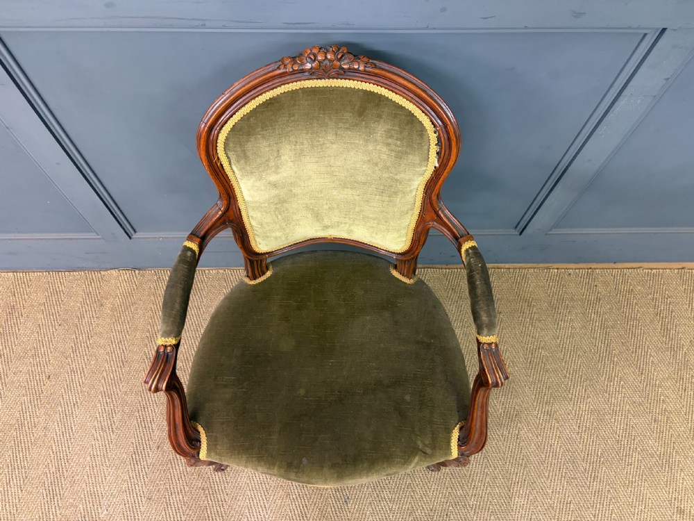 A pair of French carved mahogany fauteuil armchairs featuring cabriole legs and olive green velvet upholstery. View X